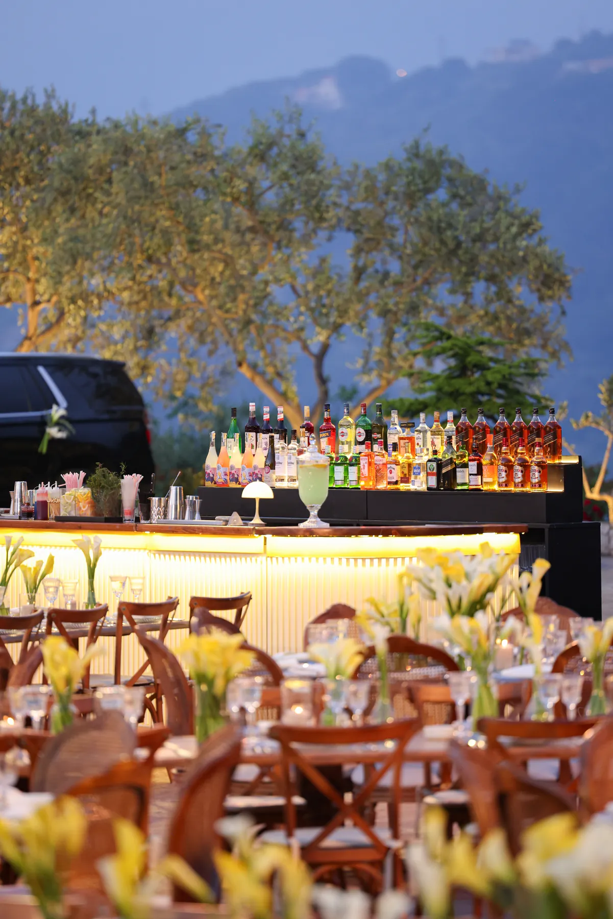 The illuminated Cream Bar seen across a warmly styled outdoor reception