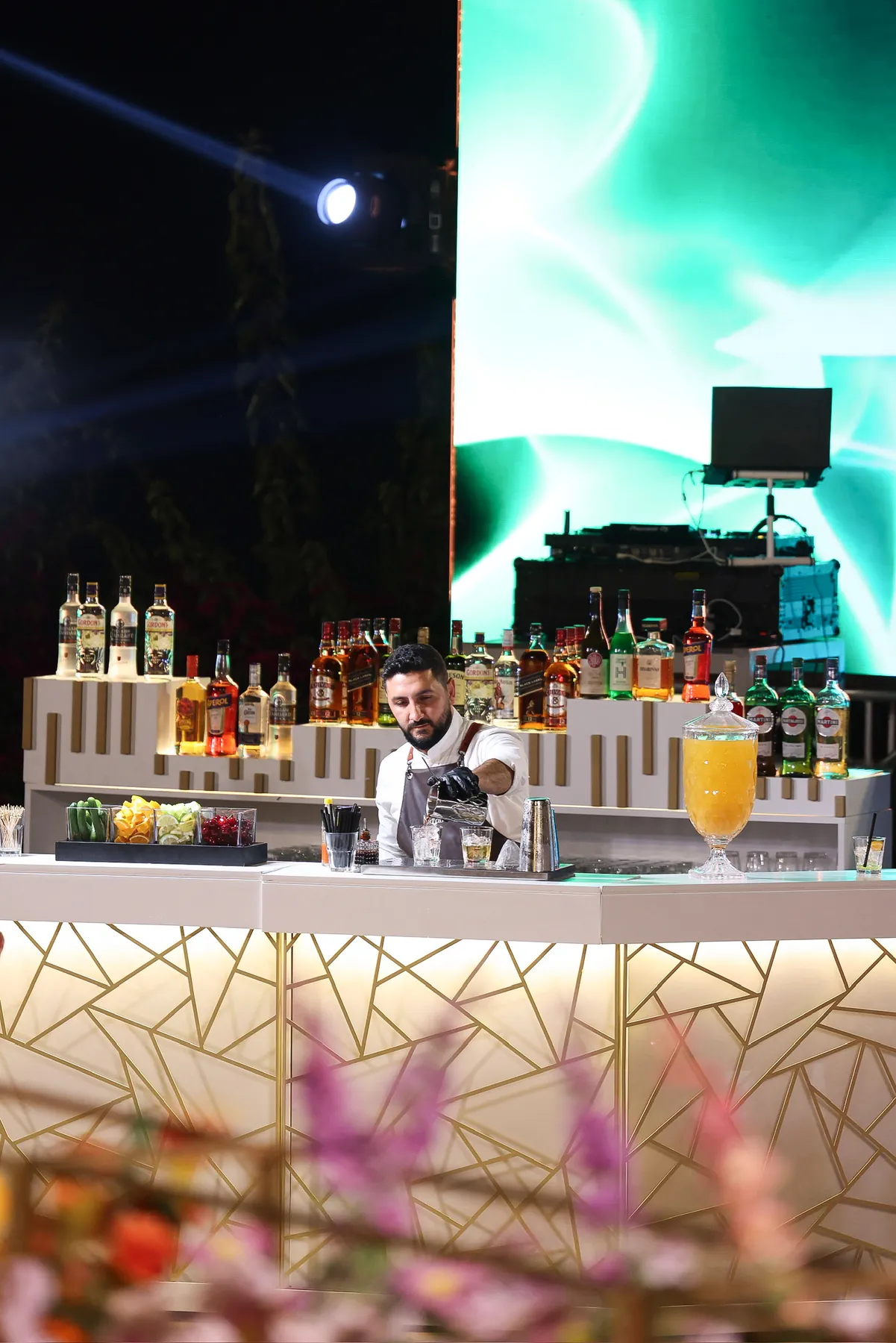 A bartender serving from the gold lattice Geometric Bar