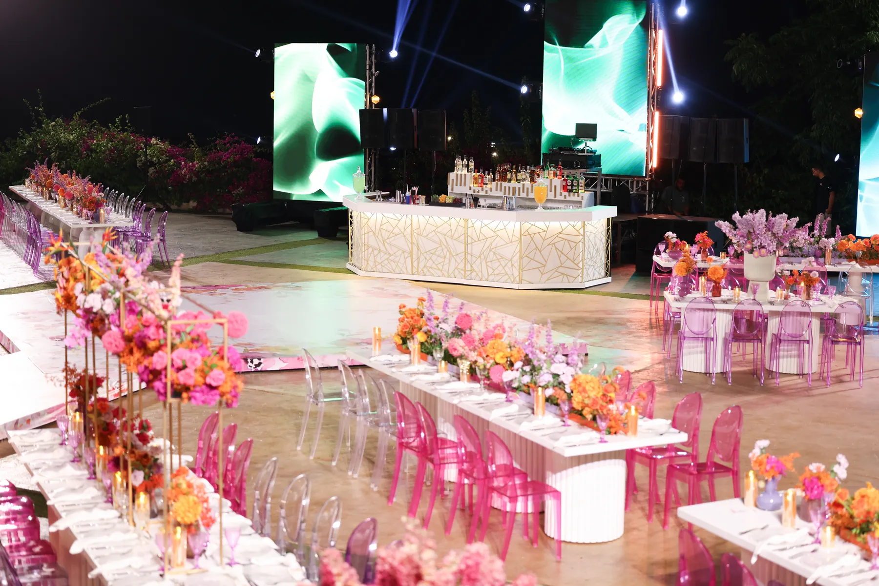 Wide reception view with the illuminated Geometric Bar and colorful table flowers