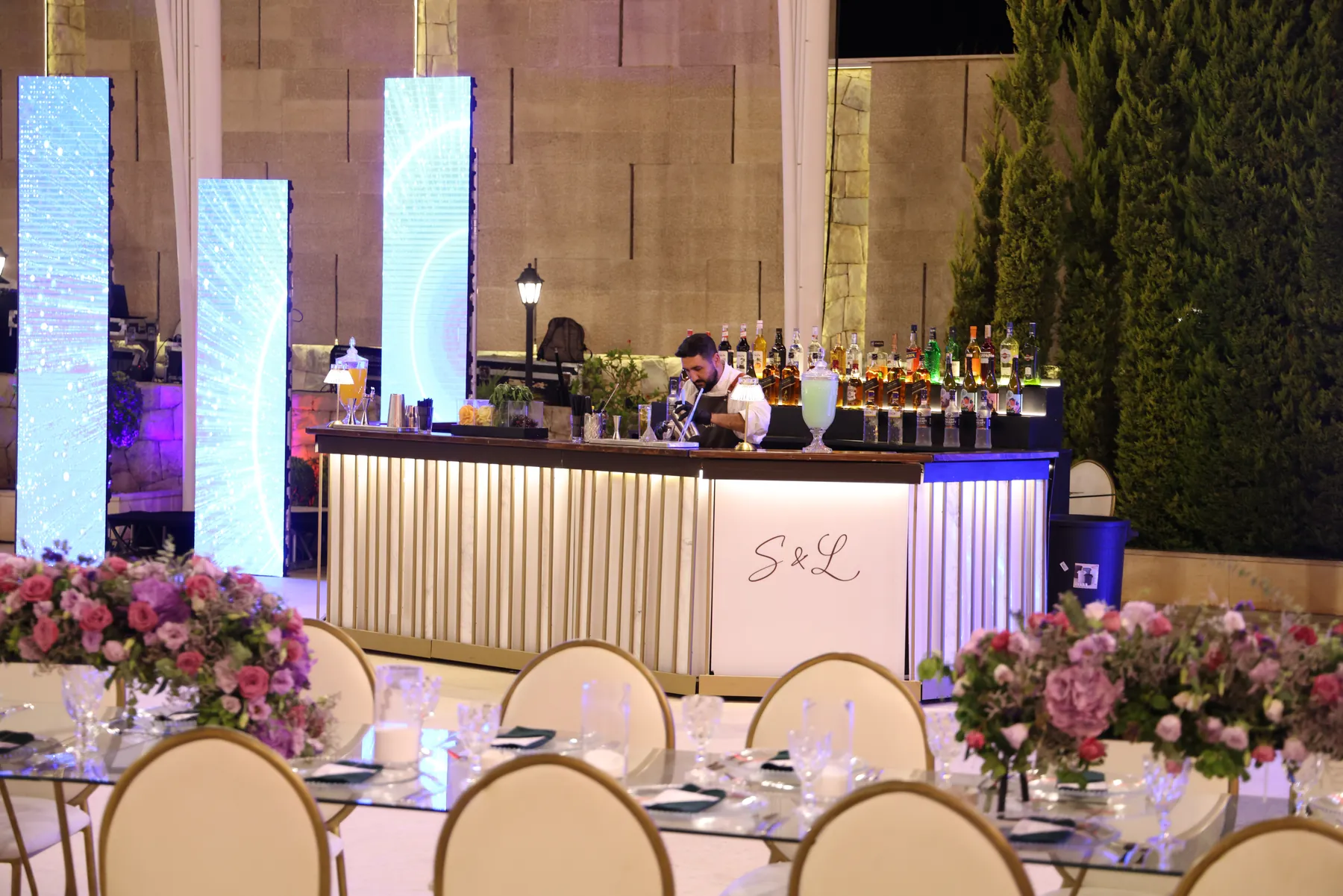 The Pannel Bar with a custom monogram viewed across a flower-filled reception