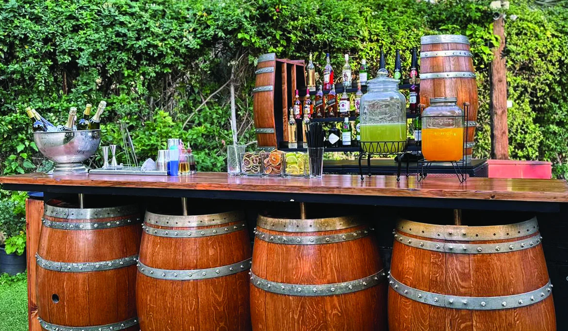 The Oak Bar by Malabar: a timber counter set on oak barrels, surrounded by greenery